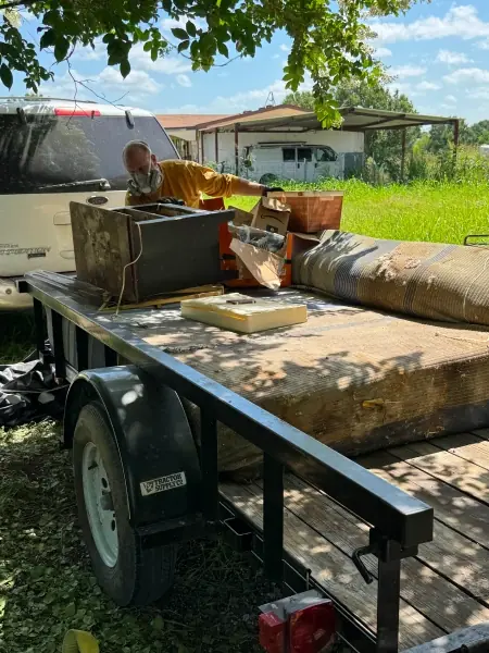 Utility trailer loaded with an old mattress and furniture