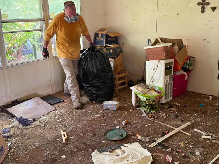 Crew member bagging trash during a hoarding cleanout