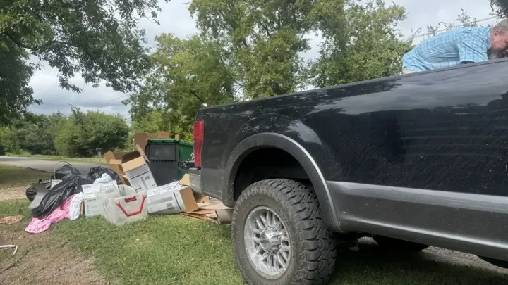 Junk pile beside a pickup at a residential pickup