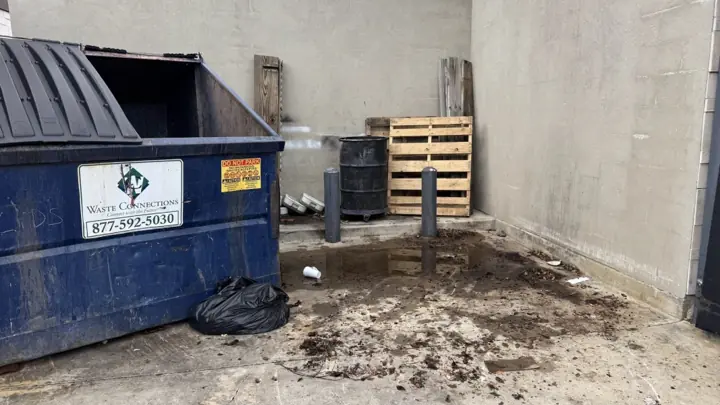 Dumpster area after debris was cleared away