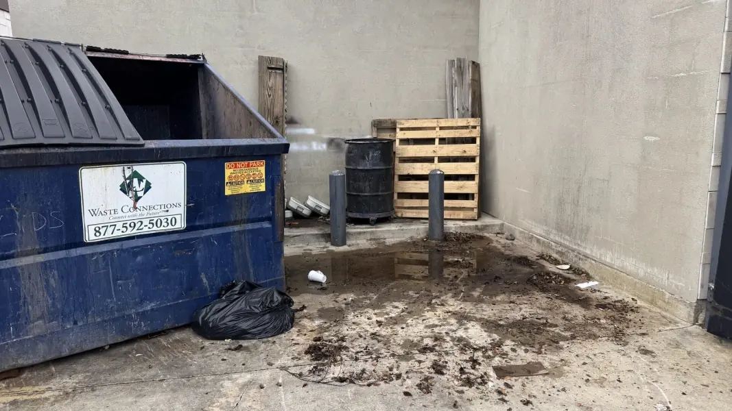 Dumpster area after debris was cleared away